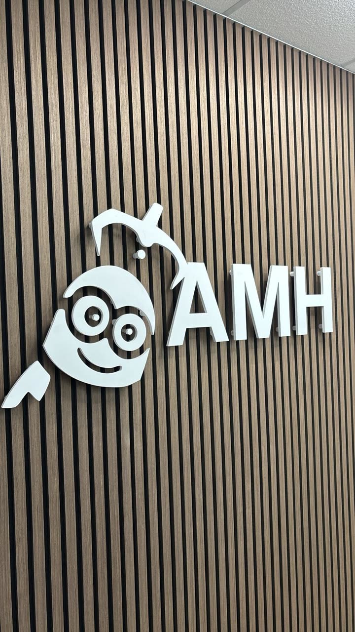 The AMH logo on the wooden slatted wall at AMH headquarters